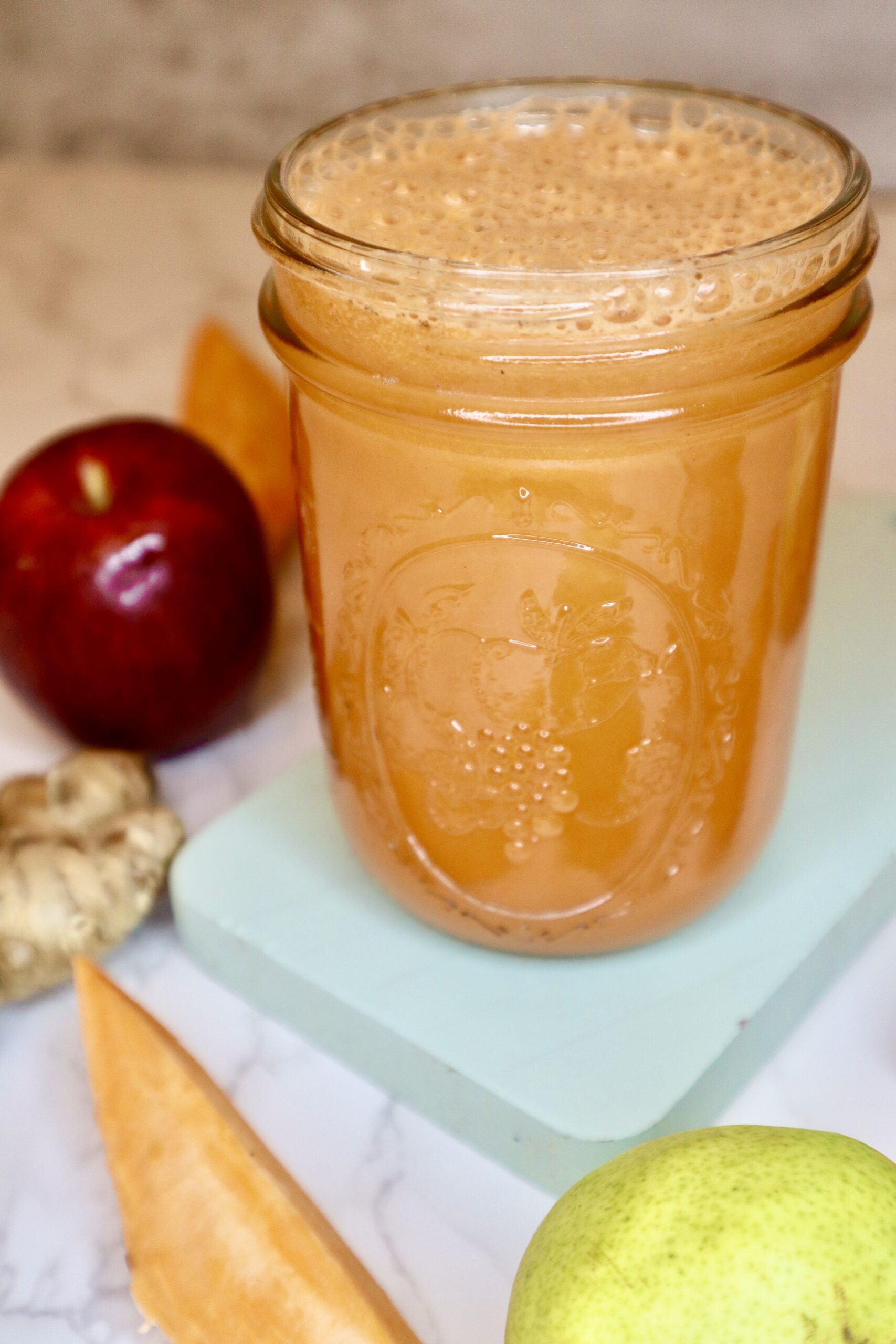 Sweet potato pie juice next to an apple and pear