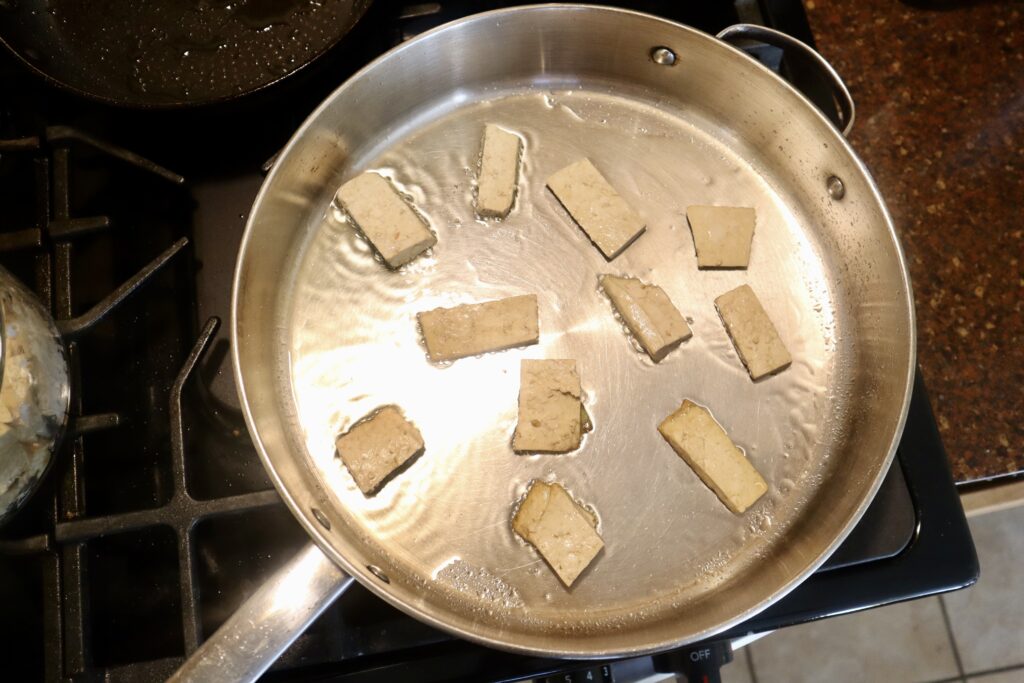 tofu frying in skillet pan