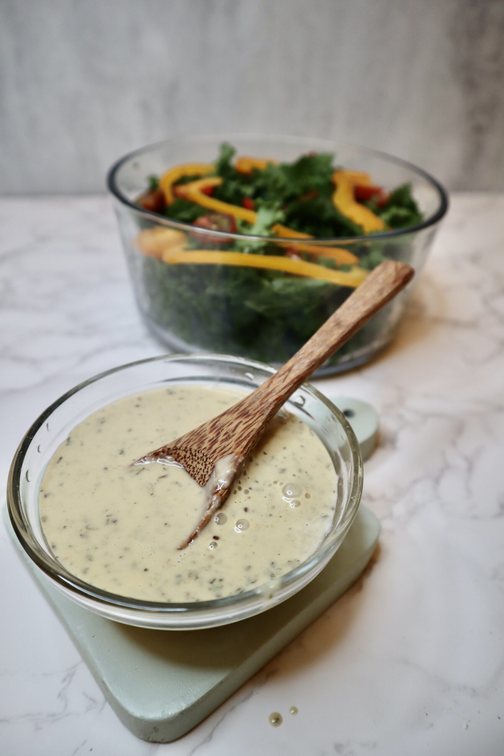 Creamy peanut tahini dressing in front of kale salad