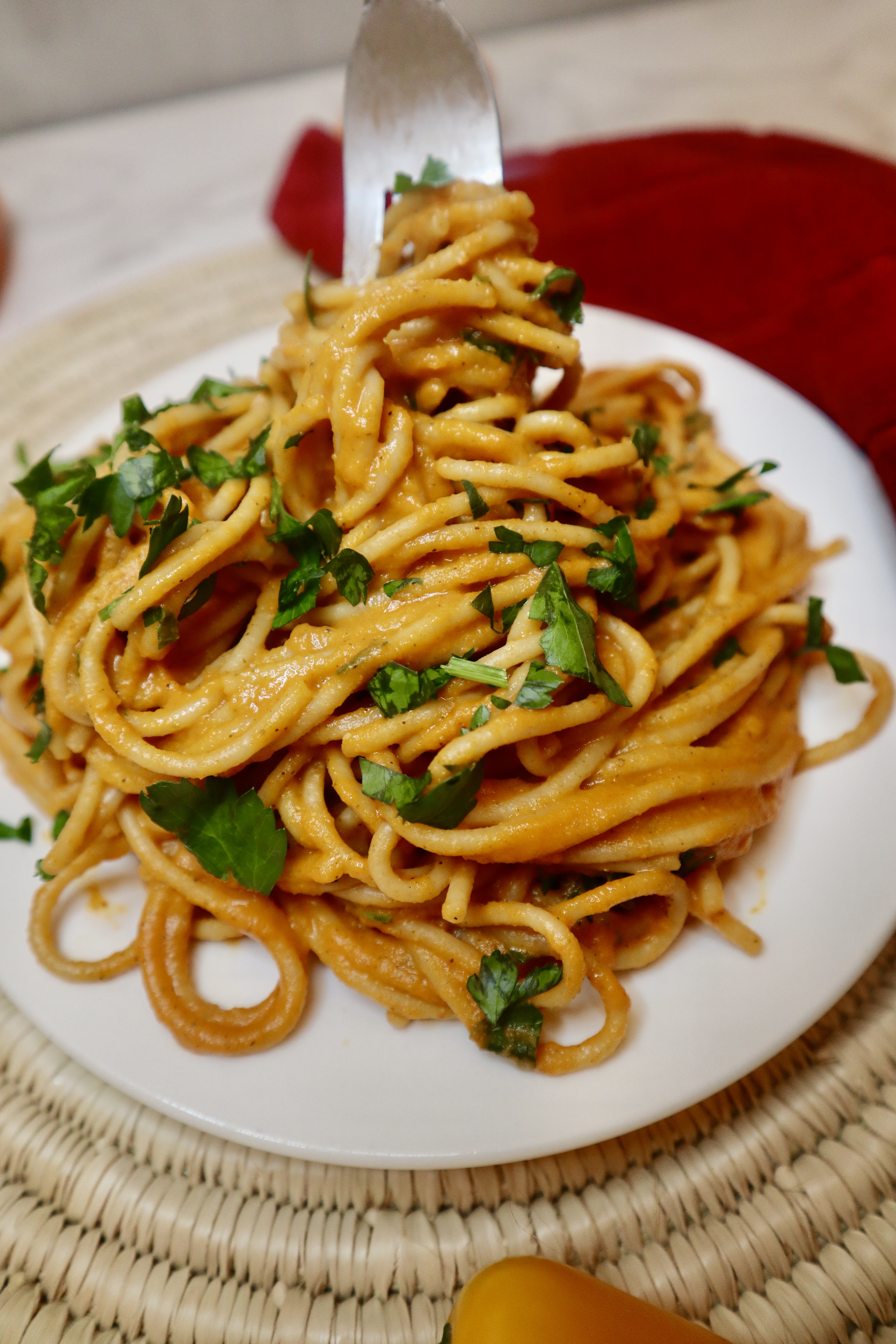 creamy vegan roasted red pepper pasta twirled with fork