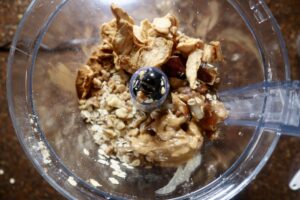 Oatmeal, walnuts, peanut butter, cinnamon, vanilla, and dried apples in a food processor