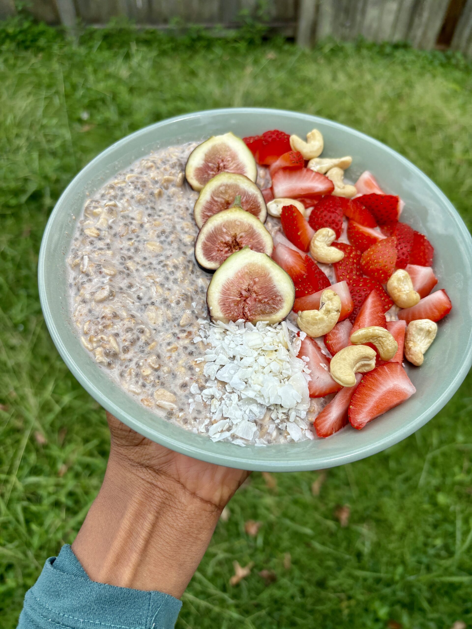 strawberry overnight oats topped with figs, strawberries, and coconut flakes