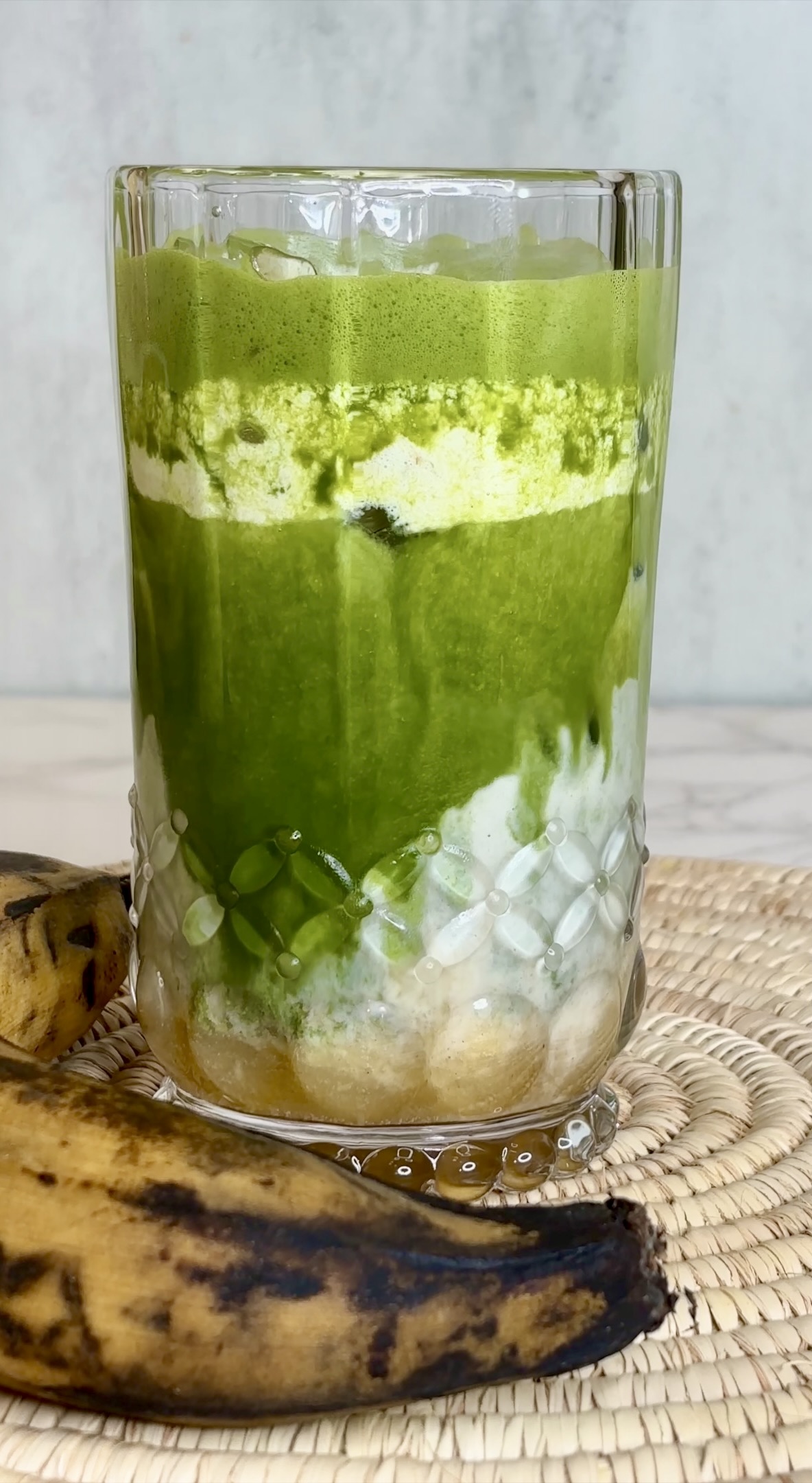 plantain matcha latte next to a ripe plantain