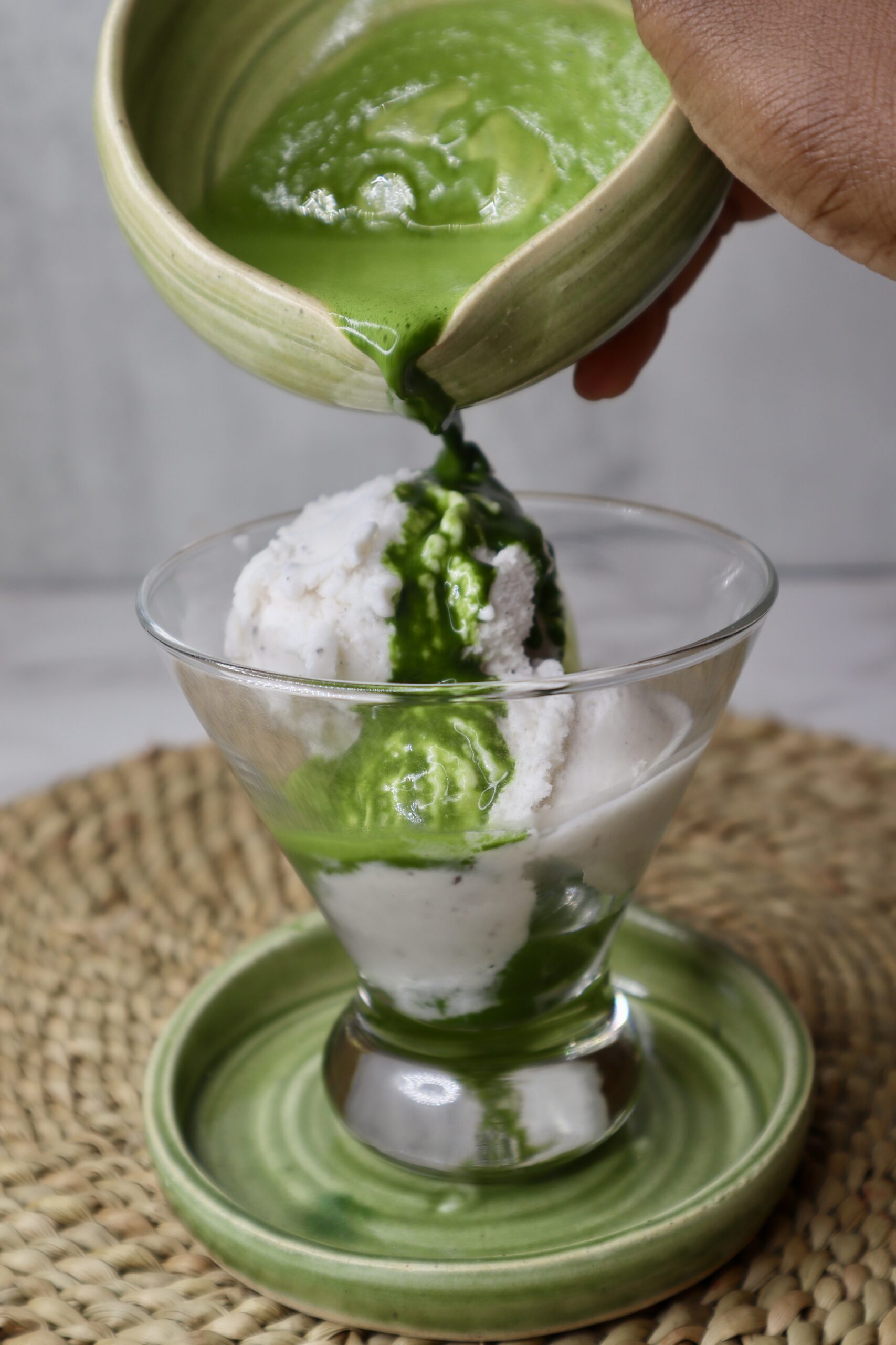 matcha shot being poured into a glass with vanilla ice cream