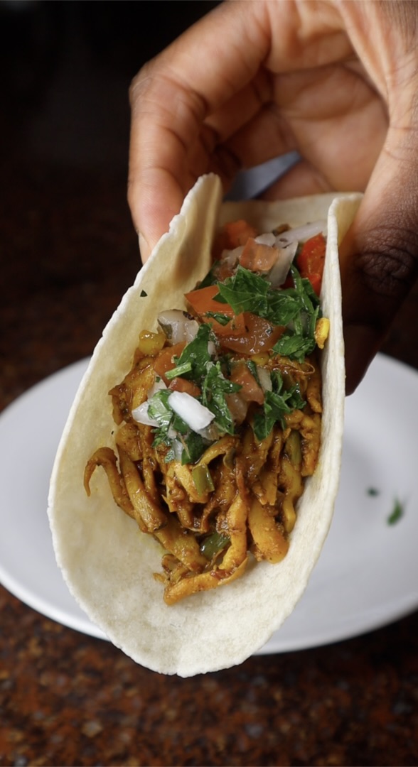 curry mushroom tacos topped with tomato and parsley