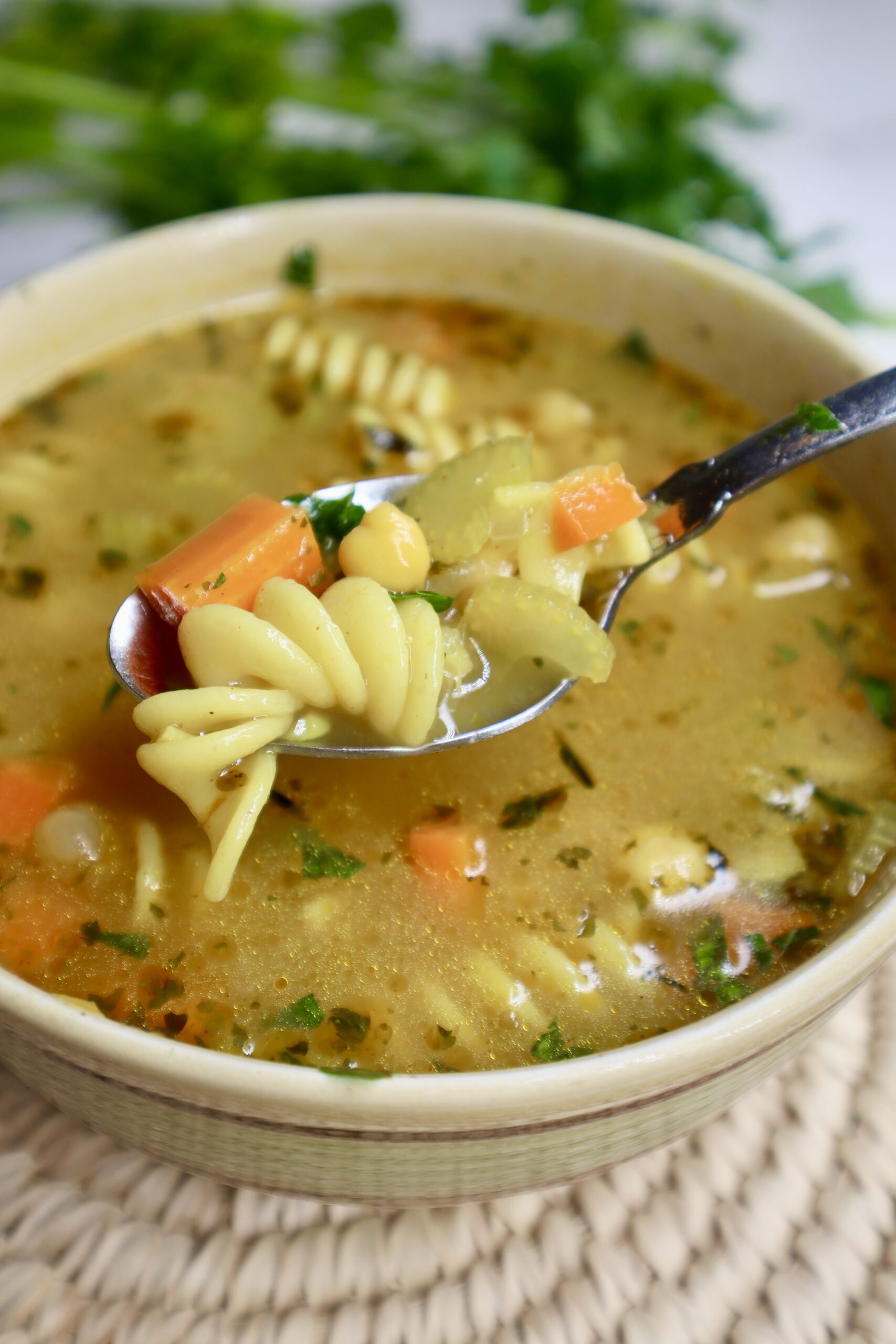 chickpea noodle soup in a tan bowl